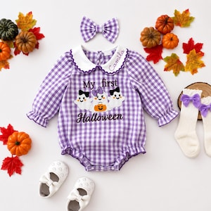 May include: A purple and white gingham long-sleeve romper with a scalloped white collar embroidered with the name Camila. The front features three ghosts and the text My first Halloween. Includes a matching hair bow and white socks.