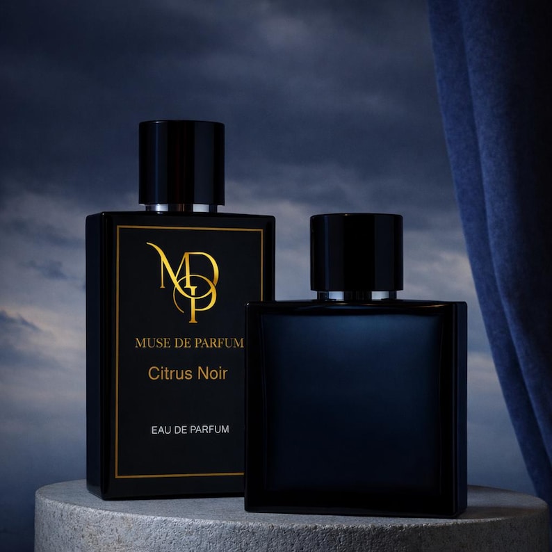 K&ouml;nnte beinhalten: Zwei schwarze, rechteckige Parf&uuml;mflaschen mit schwarzen Kappen. Die vordere Flasche hat goldfarbene Schrift, die lautet: "MUSE DE PARFUM Citrus Noir EAU DE PARFUM". Die Flaschen stehen auf einer grauen Steinoberfl&auml;che vor einem dunkelblauen, bew&ouml;lkten Hintergrund.