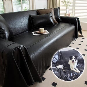 Puede incluir: Una funda de sofá de cuero negro sobre un sofá, con varias almohadas en tonos negros y marrones. Una taza de café está sobre una pequeña bandeja en el sofá. Un perro está descansando en el sofá en la imagen insertada.