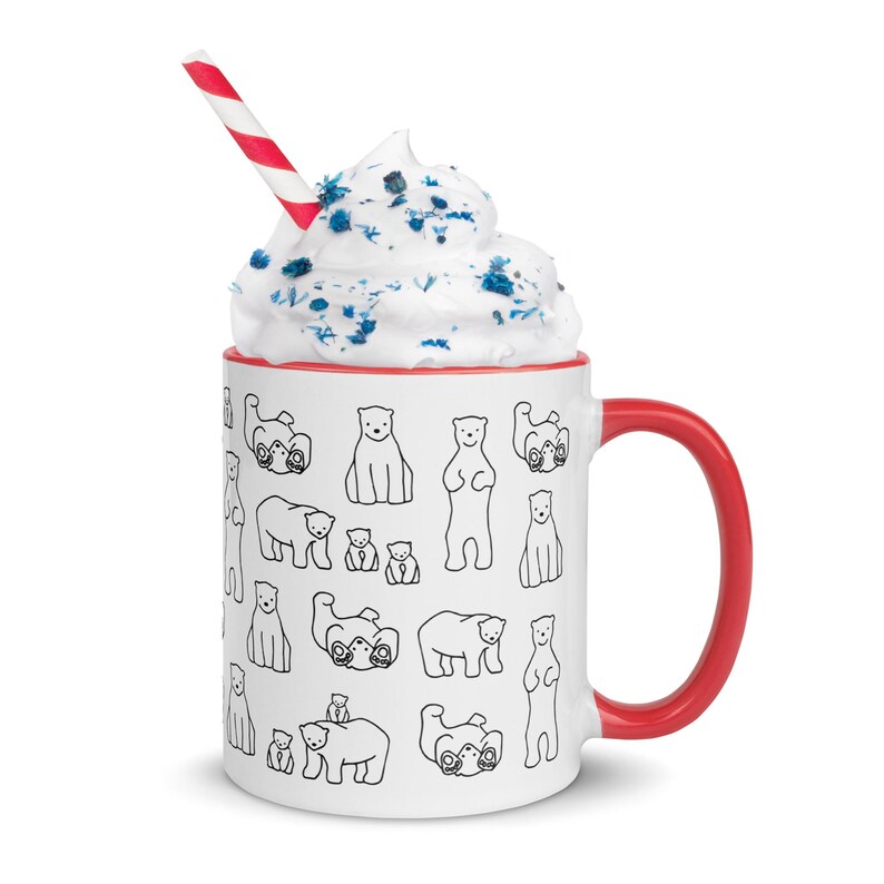 May include: White ceramic mug with a red interior and handle, filled with whipped cream and a red and white striped straw. The mug is decorated with black line drawings of polar bears in various poses.