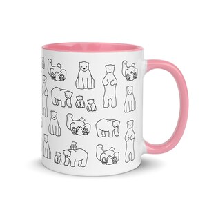May include: White ceramic mug with a pink interior and handle. The exterior features a repeating pattern of black line-drawn polar bears in various poses. The bears are standing, sitting, and lying down. A fun and whimsical design for a coffee or tea cup.