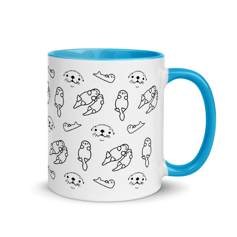 May include: White ceramic mug with a blue interior and handle. The mug features a repeating pattern of black line drawings of otters in different poses. A fun and whimsical design for a tea or coffee lover.