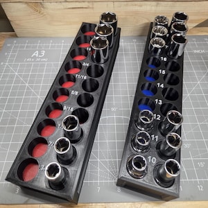 May include: Two black socket organisers with sockets of various sizes. One organiser has red felt in the socket holes, the other has blue. Sizes are labelled in inches, including 3/4, 11/16, 5/8, and 9/16.