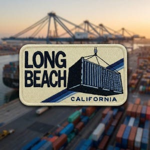 May include: A rectangular embroidered patch with a cream-colored background. It features the dark blue text LONG BEACH and CALIFORNIA, along with a graphic of a dark blue shipping container being lifted by a crane, accented by blue stripes.