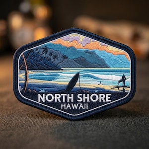 May include: A hexagonal embroidered patch featuring a North Shore Hawaii beach scene with a surfboard, palm trees, mountains, and a surfer silhouette. The design includes a sunset sky in orange and purple hues, blue ocean waves, and white text reading NORTH SHORE HAWAII.