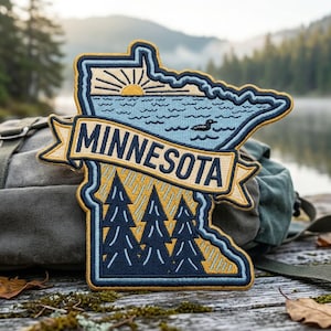 May include: An embroidered patch shaped like the state of Minnesota featuring a sunrise over a lake with a loon, a banner with the text MINNESOTA, and a forest of pine trees below. The design uses a color palette of navy blue, light blue, and gold.