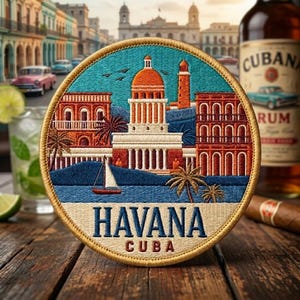 May include: A circular embroidered patch featuring a colorful Havana, Cuba cityscape with a central domed building, palm trees, and a sailboat on water. The text HAVANA CUBA is stitched in dark blue and red at the bottom against a beige background.
