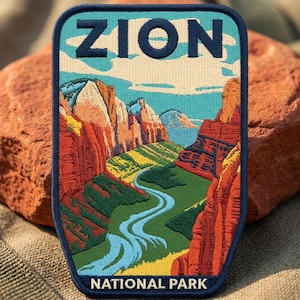 May include: A rectangular embroidered patch with rounded corners featuring a landscape of Zion National Park. The design includes red rock canyon walls, a winding blue river, green valley floor, and a light blue sky. The text ZION and NATIONAL PARK is stitched in dark blue.