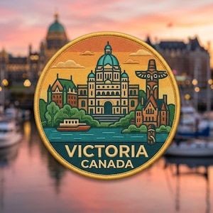 May include: A circular embroidered patch featuring a stylized illustration of the British Columbia Parliament Buildings in Victoria, Canada. The design includes a totem pole, a boat on water, and the text VICTORIA CANADA in a gold border.