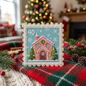 May include: A square embroidered patch shaped like a postage stamp featuring a gingerbread house on a light blue background. The design includes white snowflakes, two green pine trees, and the number 40 in white text above the house roof.