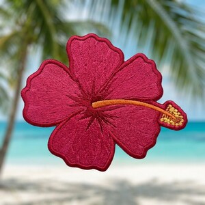 May include: A vibrant dark pink hibiscus flower embroidered patch with five rounded petals. The center features a long, thin orange stamen extending to the right, tipped with a textured yellow pollen-covered anther, all rendered in detailed thread.
