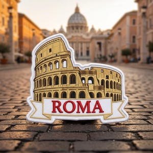 May include: An embroidered patch featuring a golden-brown depiction of the Colosseum in Rome. Below the structure is a white banner with a gold border containing the red text ROMA. The patch has a white stitched border and a detailed design.