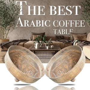 May include: Two wooden, oval-shaped serving trays with intricate carved designs. The trays are light brown and rest on small, rounded feet. The background features a living room setting with a coffee table and the text "THE BEST ARABIC COFFEE TABLE".