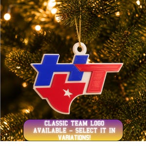 May include: A white, blue, and red 3D-printed ornament featuring the letters HT with a Texas state shape integrated into the design, including a white star. The ornament has a circular loop at the top with a gold string for hanging on a tree.