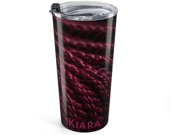Op de afbeelding: Een roestvrijstalen reisbeker met een doorzichtig deksel en een zwarte sluiting. De beker is bedekt met een close-up van diep magenta garen. Het woord "KIARA" is in roze op de bodem van de beker gedrukt.