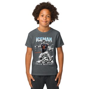 May include: Dark gray t-shirt featuring a graphic of a football player with the text "ICEMAN" above and "CALEB WILLIAMS" below. The player is wearing a black and orange uniform. The shirt is short-sleeved.
