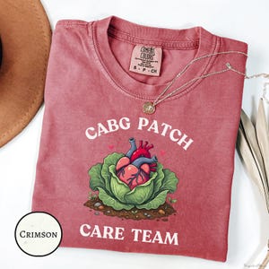 May include: A white ceramic mug with a black handle and the text "But First, Coffee" in a black, handwritten-style font. The mug is on a white surface.