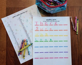 Puede incluir: Dos hojas de trabajo educativas tituladas Sight Word Master List y Rainbow Write con texto colorido y líneas en blanco para practicar la escritura, acompañadas de un estuche azul transparente lleno de ceras de colores y ceras sueltas.