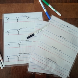 May include: Two laminated handwriting practice sheets featuring the letter Y with sections labeled Learn It, Practice It, Practice It Again, and Write It By Yourself. Five dry-erase markers in pink, orange, blue, green, and black are included.