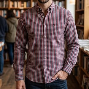 Può includere: Una camicia a maniche lunghe con bottoni caratterizzata da un motivo a quadri rosso, bianco e blu navy. La camicia presenta un colletto button-down, un'abbottonatura frontale e una piccola etichetta rettangolare con logo sul petto.