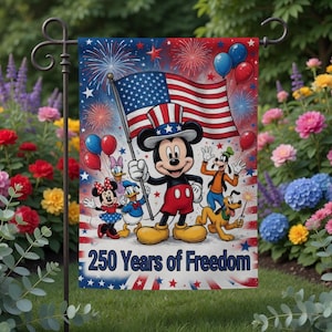 K&ouml;nnte beinhalten: Eine Gartenflagge mit Mickey Mouse, die eine amerikanische Flagge h&auml;lt, umgeben von anderen Disney-Figuren. Die Flagge hat ein rot-wei&szlig;-blaues Farbschema mit Feuerwerk und Luftballons. Der Text auf der Flagge lautet "250 Years of Freedom".