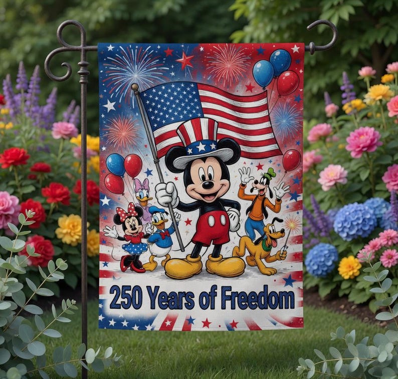 K&ouml;nnte beinhalten: Eine Gartenflagge mit Mickey Mouse, die eine amerikanische Flagge h&auml;lt, umgeben von anderen Disney-Figuren. Die Flagge hat ein rot-wei&szlig;-blaues Farbschema mit Feuerwerk und Luftballons. Der Text auf der Flagge lautet "250 Years of Freedom".