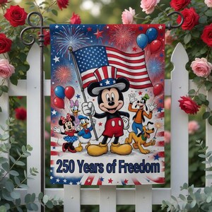 K&ouml;nnte beinhalten: Eine dekorative Gartenflagge mit Mickey Mouse, die eine amerikanische Flagge h&auml;lt, mit Feuerwerk und Luftballons im Hintergrund. Weitere Disney-Figuren sind ebenfalls abgebildet. Die Flagge tr&auml;gt die Aufschrift "250 Years of Freedom".