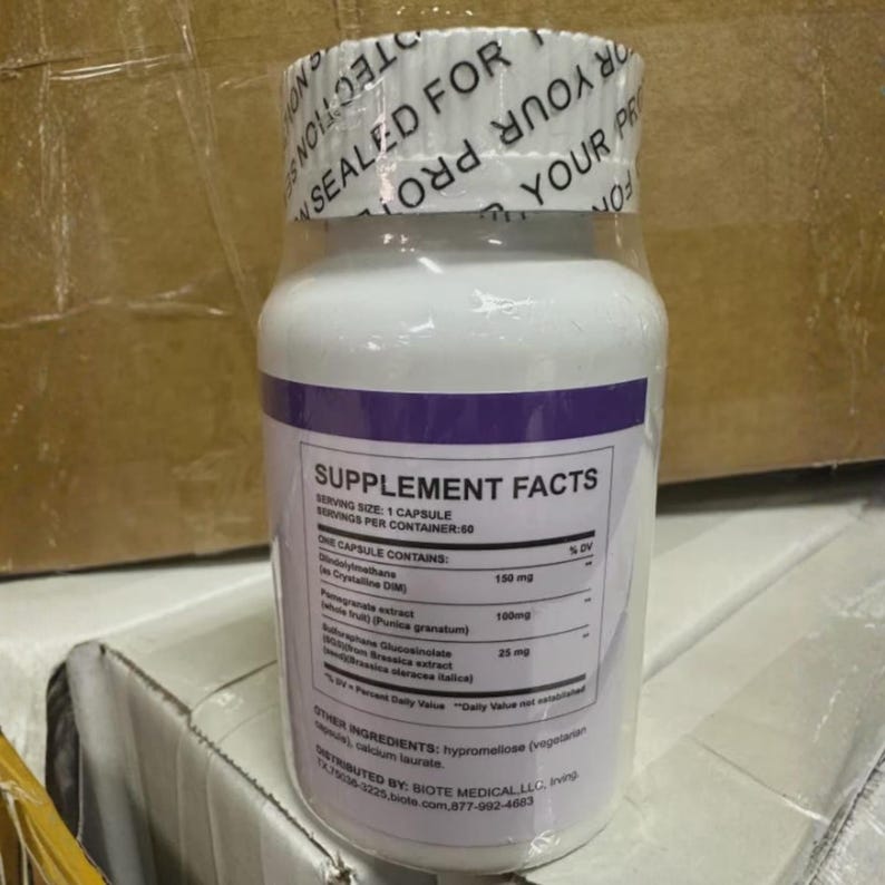 Puede incluir: Una botella de suplemento blanca con una banda morada y un sello de pl&aacute;stico transparente. La etiqueta dice "Supplement Facts" y enumera ingredientes como "Diindolylmethane" y "Extracto de granada". La botella est&aacute; sellada para protecci&oacute;n.