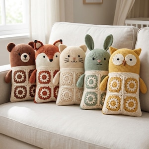 Peut inclure: Un ensemble de cinq peluches au crochet en forme d'ours, de renard, de chat, de lapin et de hibou. Chaque jouet présente une tête et des bras unis avec un corps crème composé de quatre carrés au crochet de style granny à motifs floraux.
