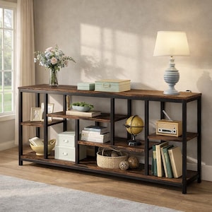 May include: A rustic, industrial-style console table with a dark brown wooden top and black metal frame. The table features multiple shelves displaying decorative items like books, a globe, a lamp, and boxes. A vase of flowers adds a touch of color.
