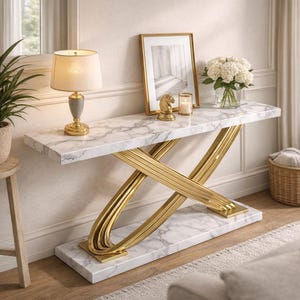 May include: A marble-topped console table with a gold-colored, geometric base. The table features a white and gray marble surface and is decorated with a lamp, picture frame, and flowers. The table is approximately 48 inches long.