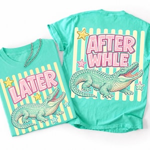 May include: Two turquoise t-shirts with a cartoon alligator design. One shirt says "LATER" and the other says "AFTER WHLE" in pink bubble letters. Both shirts have a yellow and white striped background with star accents.