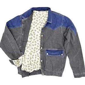 Puede incluir: Chaqueta vaquera de dos tonos. Los hombros y el cuello son de un azul más oscuro, mientras que el cuerpo es gris descolorido. La chaqueta tiene un forro blanco estampado y dos bolsillos delanteros. Los puños están doblados, revelando el forro estampado.