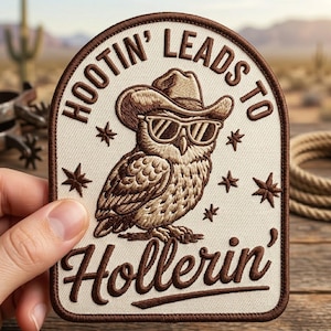 May include: Embroidered patch featuring a brown owl wearing a cowboy hat and sunglasses. The patch has the text "Hootin' Leads to Hollerin'" in a brown arched border with star accents. The patch is held by a hand.