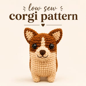 May include: A small, crocheted corgi plush toy with brown and cream yarn, featuring large black plastic eyes and a dark brown nose. Above the toy, the text reads "low sew corgi pattern" in dark brown letters with a small heart icon below.