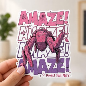 May include: A die-cut sticker featuring a rocky, pink, multi-limbed creature centered over the repeated text "AMAZE!" in pink and purple. Small space-themed icons like a planet, star, and astronaut are included, with "Project Hail Mary" at the bottom.