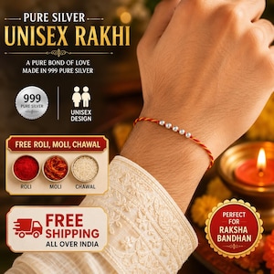 Puede incluir: Una pulsera rakhi con cinco pequeñas cuentas de plata pura 999 pulida, ensartadas en un hilo trenzado rojo y dorado. La pulsera se lleva en la muñeca, mostrando el brillo metálico de la plata sobre el cordón de colores vibrantes.