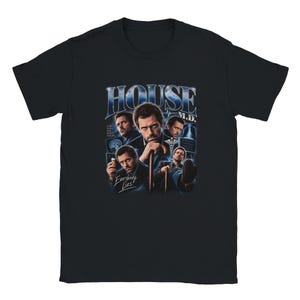 Op de afbeelding: Een zwart t-shirt met korte mouwen en een grafische print van de televisieserie House M.D. Het ontwerp bevat meerdere afbeeldingen van het hoofdpersonage, een wandelstok, medische beelden en de tekst HOUSE M.D. en Everybody Lies.