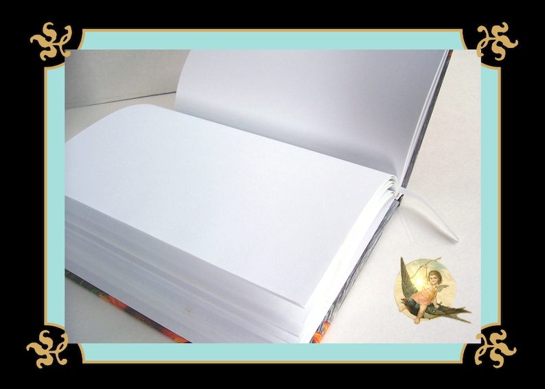 May include: An open hardcover book with blank white pages and a thin white ribbon bookmark. The book features a dark cover with orange floral patterns visible at the edges. A small circular sticker depicting a winged cherub is placed on the page.
