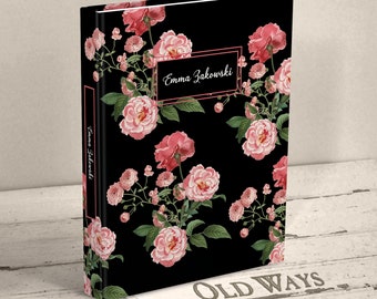May include: A black hardcover book featuring a floral pattern of pink roses and green leaves. The front cover displays a rectangular frame with the white text Emma Zakowski, and the spine also features the name Emma Zakowski in white text.