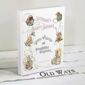Puede incluir: Un libro blanco con un t&iacute;tulo rosa y negro que dice "Stephanie's Baby Shower Good Wishes and Parenting Wisdom" con una fecha del 10 de octubre de 2018. La portada del libro presenta ilustraciones de animales del libro "El cuento de Peter Rabbit" incluyendo Peter Rabbit, Jemima Puddle-Duck, Mrs. Tiggy-Winkle y los dos ratones malos.
