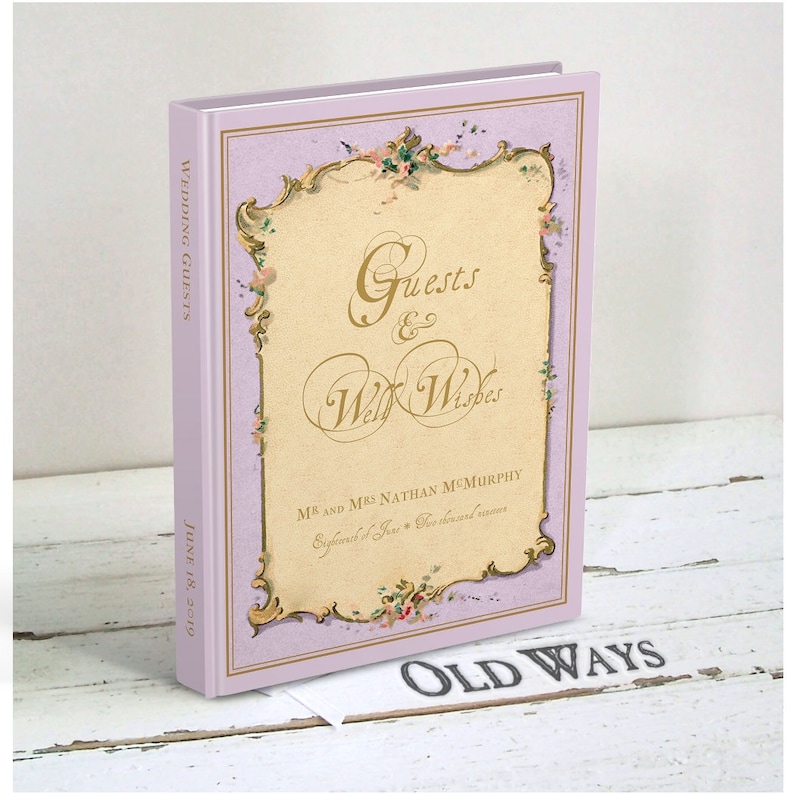 May include: A lavender-colored book with a gold-trimmed cover and floral accents. The title is "Guests & Well Wishes" with the text "Mr. and Mrs. Nathan McMurchy" and "June 18, 2019" on the cover. The book is titled "Old Ways" on the bottom.