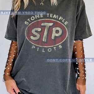 K&ouml;nnte beinhalten: Dunkelgraues T-Shirt mit dem Stone Temple Pilots-Logo in Rot und Wei&szlig;. Das Shirt hat einen Used-Look im Vintage-Stil. Der Text "DONT COPY MY STYLE" ist unten auf dem Shirt aufgedruckt.