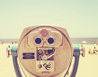 May include: A vintage-style coin-operated viewer with a silver and blue body. The viewer has two round viewing ports and a sign that reads "TURN TO CLEAR VISION" and "QUARTERS ONLY".