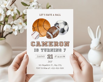May include: A white invitation card with watercolor illustrations of a basketball, soccer ball, baseball, and football. The text reads "LET'S HAVE A BALL" and "CAMERON IS TURNING 7". Includes date, time, and RSVP information.
