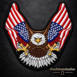 May include: An embroidered patch featuring a bald eagle with brown and white feathers, a yellow beak, and yellow talons. The eagle's wings are depicted as American flags with red and white stripes and blue fields with white stars. The text reads theultimateleather.