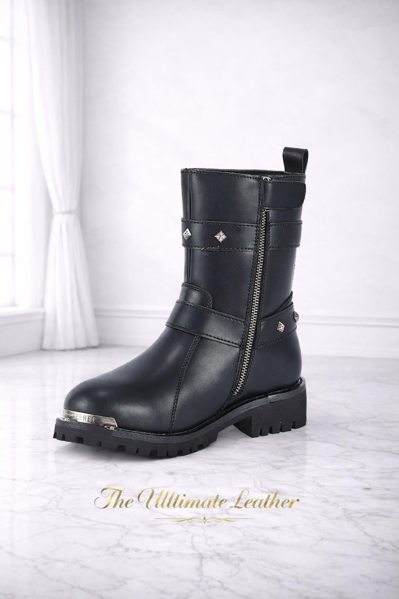 May include: Black leather ankle boot with a side zipper, studded accents, and buckle straps. The boot has a silver-toned toe cap and a lug sole. The text "The Ultimate Leather" is at the bottom.