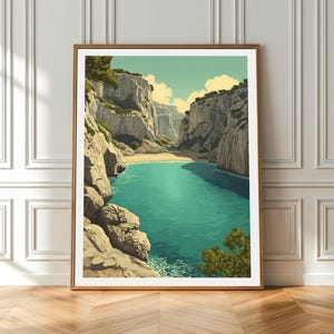 May include: A framed art print depicting a coastal landscape with turquoise water, sandy beach, and towering cliffs. The artwork features a serene scene with a light blue sky and touches of green foliage. The frame is a warm brown color, adding to the artwork's aesthetic.