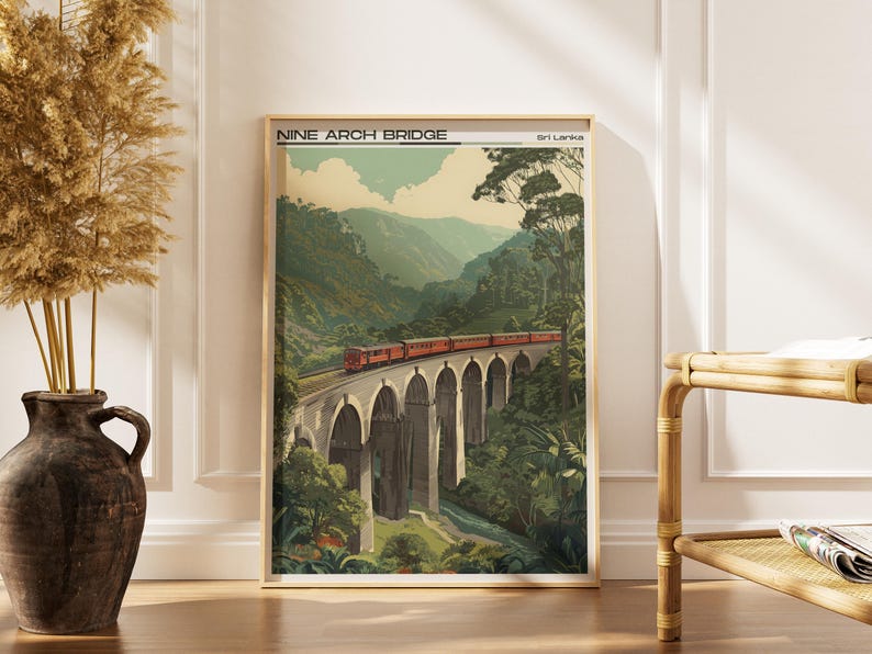 May include: A framed print of the Nine Arch Bridge in Sri Lanka. The artwork shows a red train crossing the bridge, set against a backdrop of green mountains and foliage. The print has a vintage aesthetic.