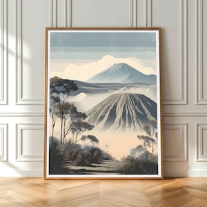 Könnte beinhalten: Ein gerahmter Kunstdruck mit einer Berglandschaft in Blau-, Grau- und Beigetönen. Das Kunstwerk zeigt einen Vulkanberg mit strukturierter Oberfläche, Bäumen und einem bewölkten Himmel. Der Druck wird auf einem Holzboden präsentiert.